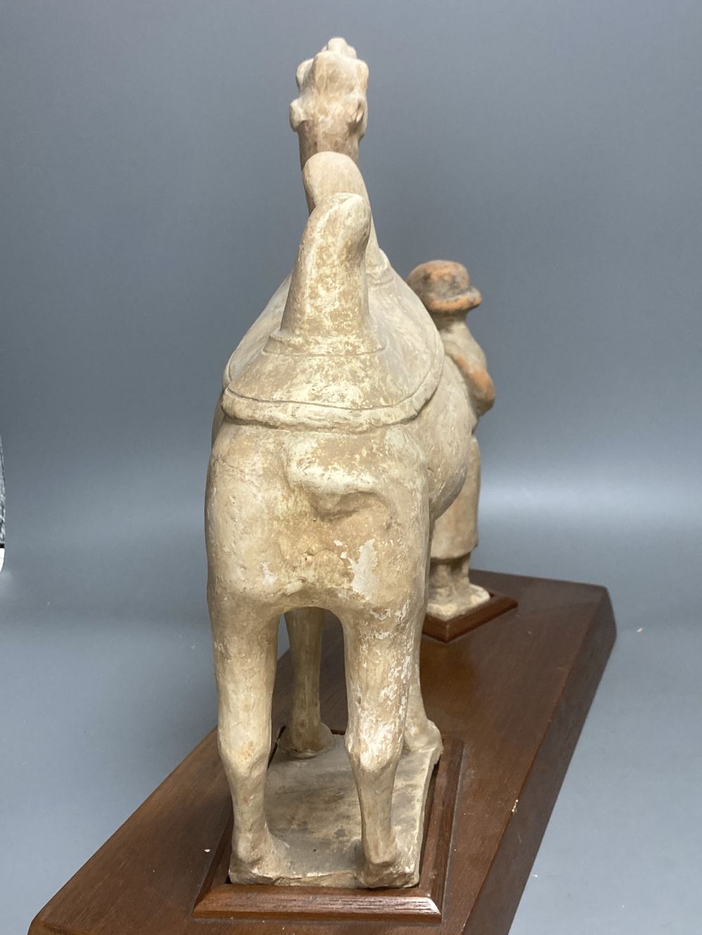 A group of Chinese Tang style pottery figures, tallest 28cm and a partially glazed ewer in sancai colours against a blue ground, 40cm